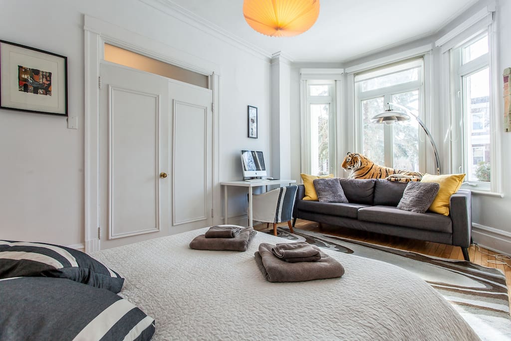 Chambre principale avec coin bureau et canapé pour lire au soleil.