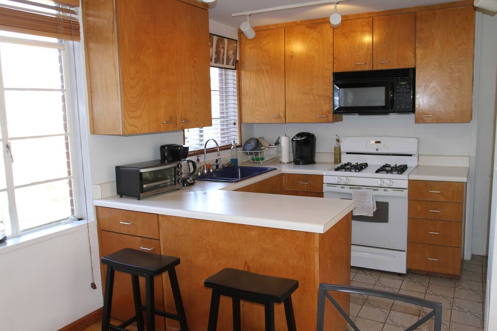 clean crisp kitchen with breaks bar and pool view from second story