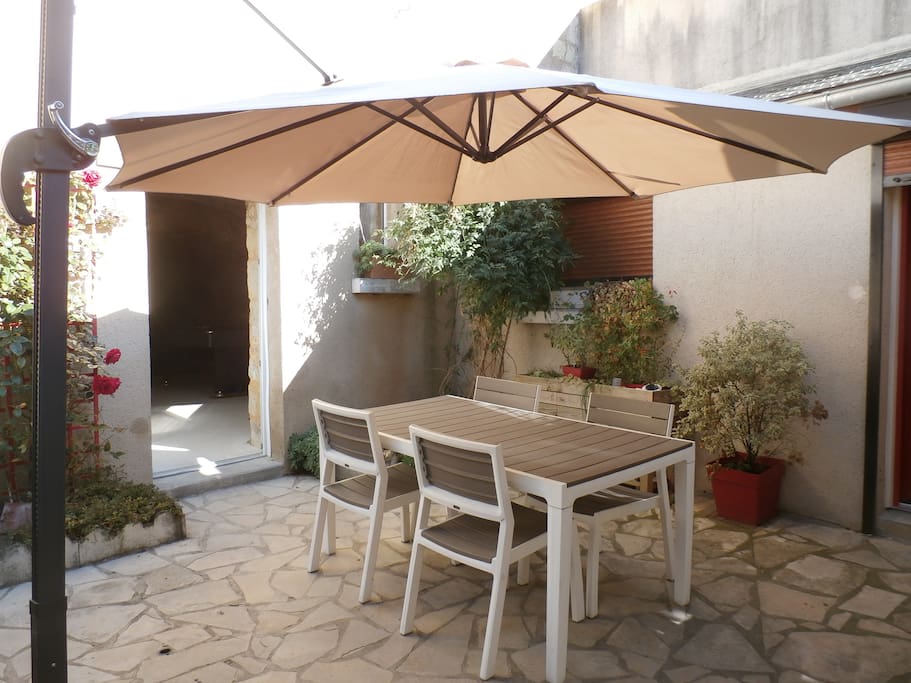 La cour : un large parasol l'ombrage.