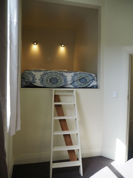 Queen sized bed in sleeping nook.