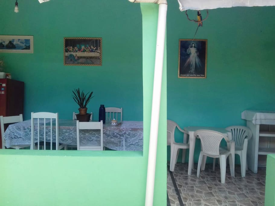 área com cozinha compartilhada, fogão, geladeira, e espaço para mesas e cadeiras