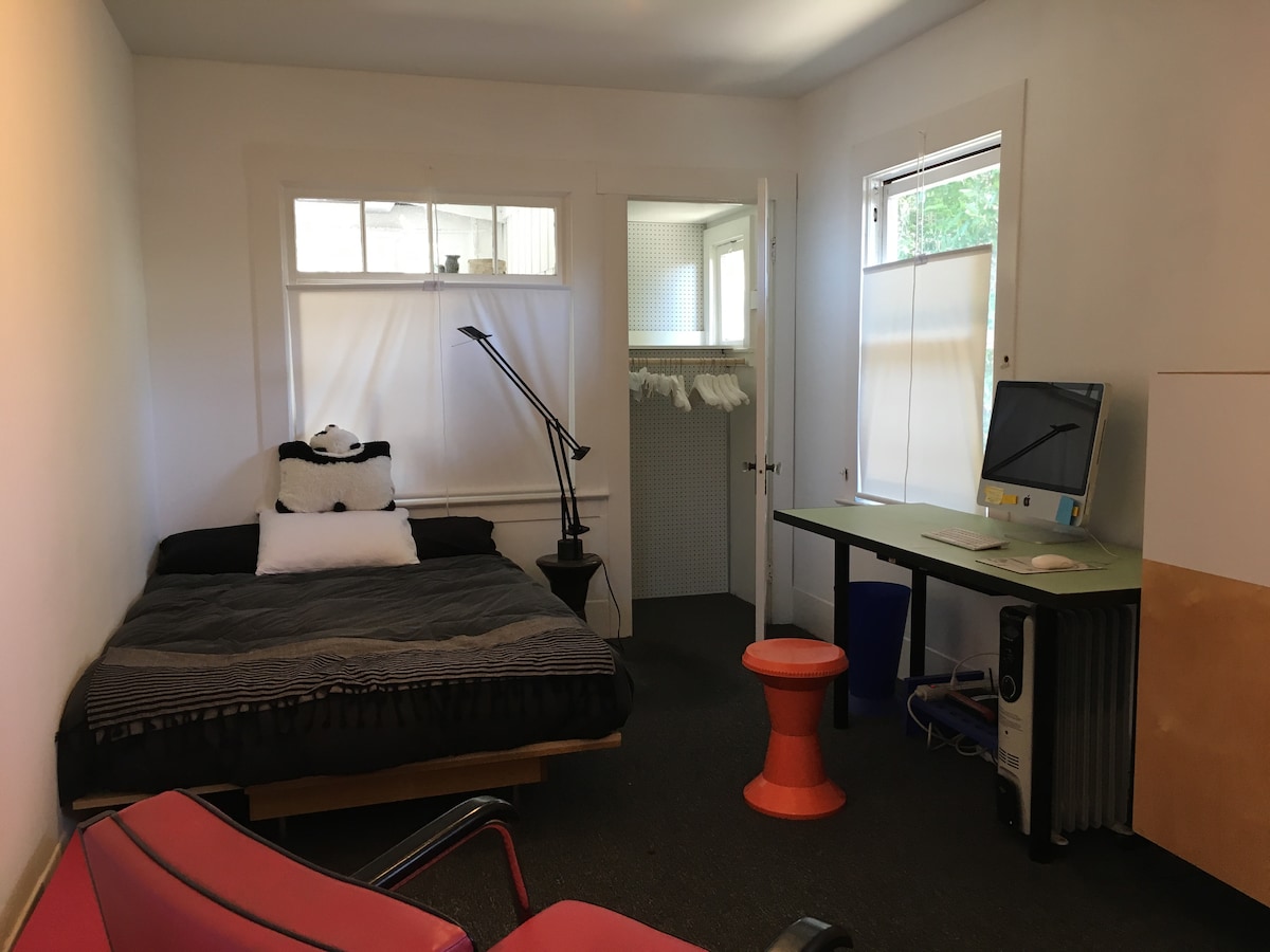 เตียงที่มีตู้เสื้อผ้าและโต๊ะคอมพิวเตอร์