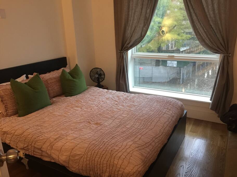Spacious bedroom with queen size bed & with large picture window overlooking park