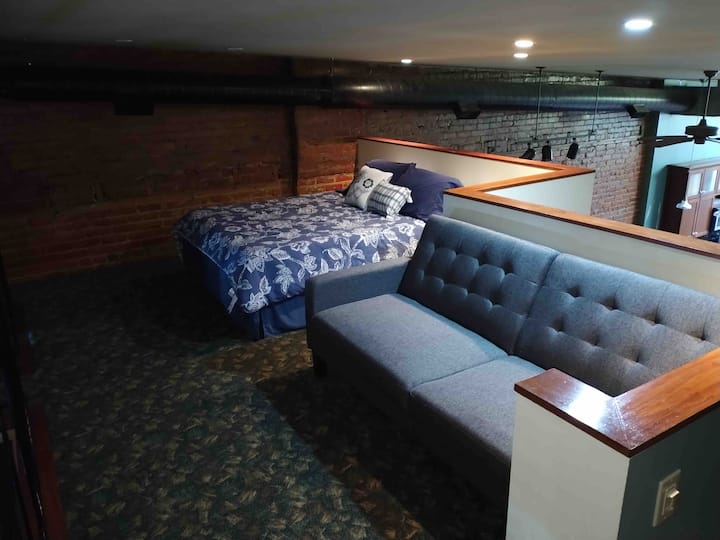 Lofted bedroom with pull out couch. 