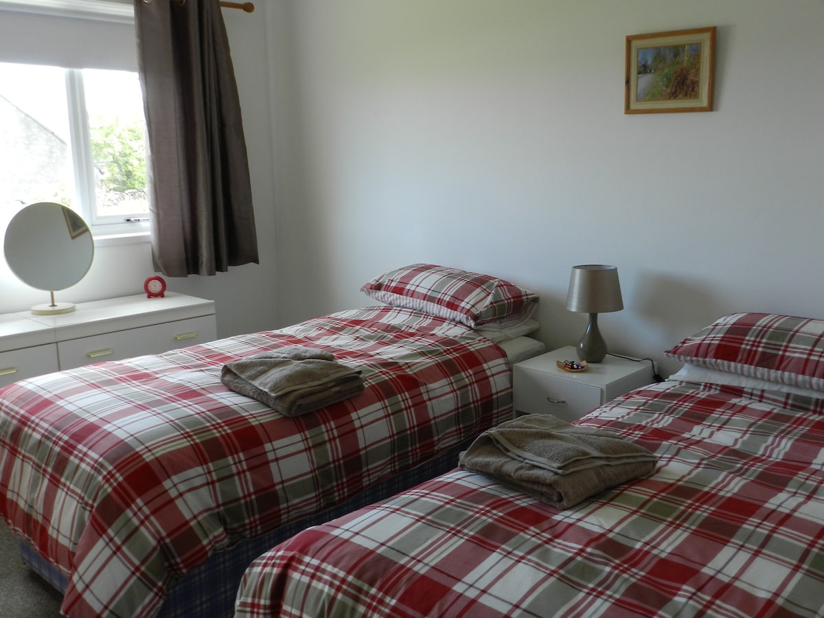 Bedroom 2 is a twin bedroom with views over the garden and Lochindaal.
