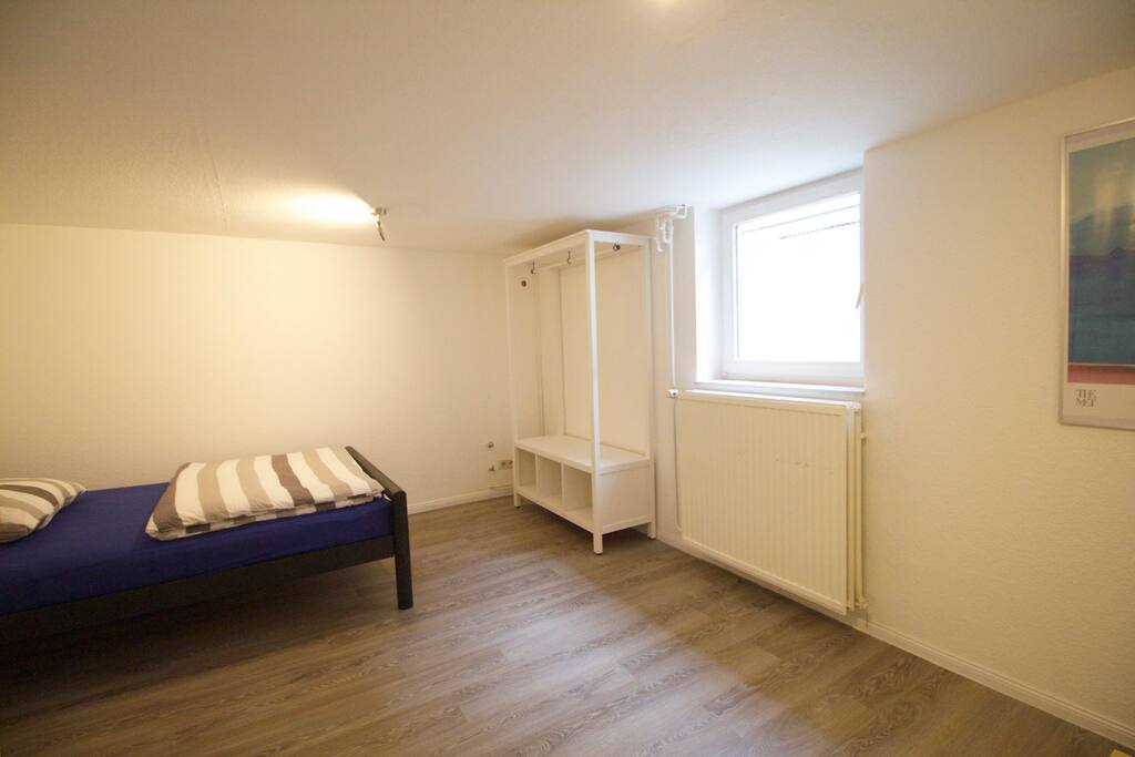 Zimmer mit Doppelbett, Tisch und Stühlen und Kleiderschrank