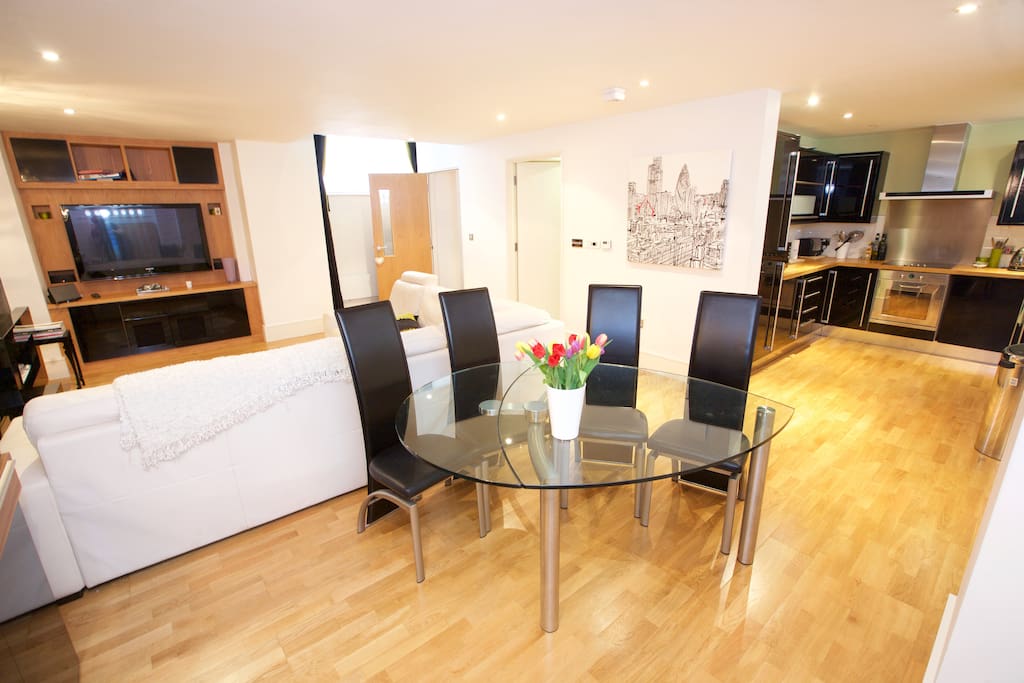 Here is the main reception room: a large sofa area to relax and watch TV, dining table that comfortably seats up to four, opening up into the kitchen