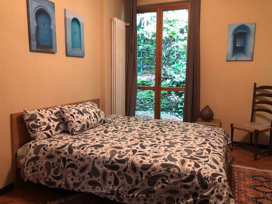 Cozy bedroom with beautiful woods and flowering vines right outside the window