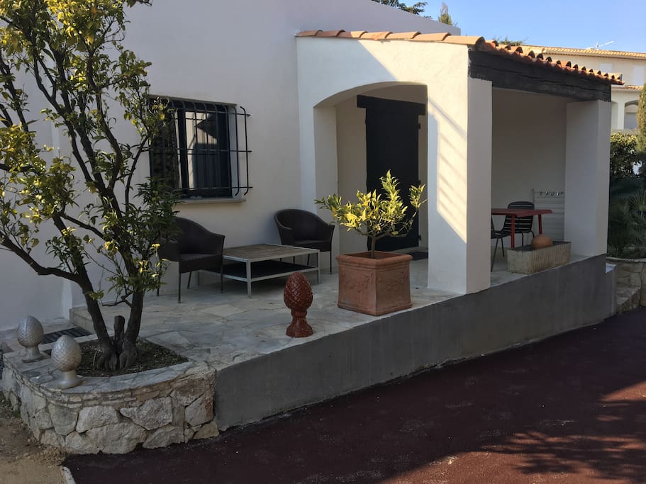 Terrasse couverte avec table et chaises et salon extérieur