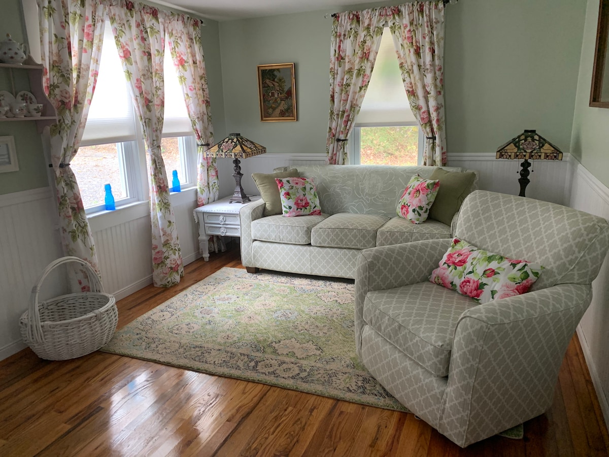 Прясно декорирана всекидневна с персонализиран диван с пълен размер и сгъваем стол.