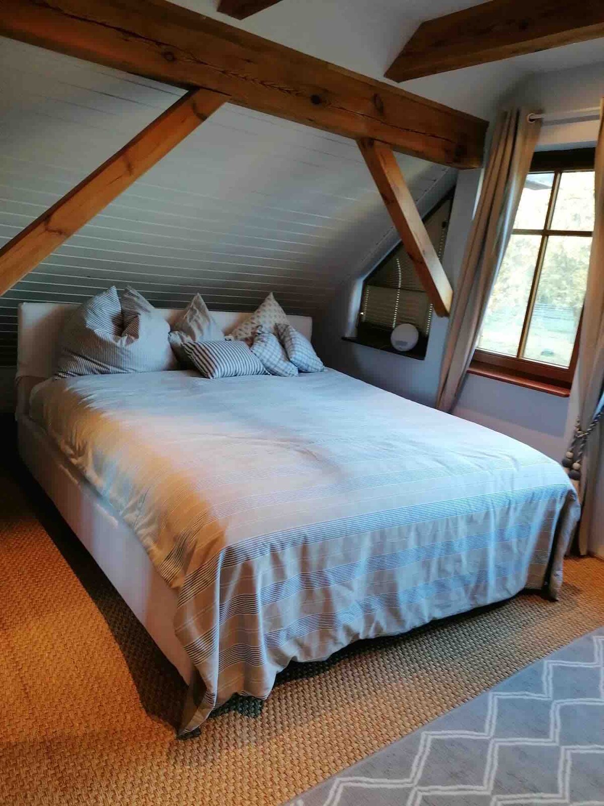 Chumba tofauti cha kulala chenye kitanda cha ukubwa wa kifalme na sofa kwenye ghorofa ya kwanza.