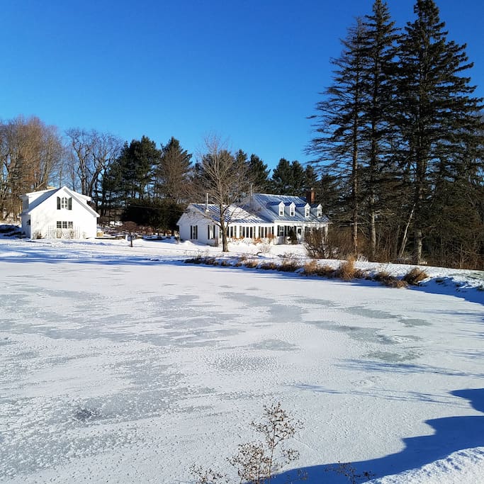 Guest house and Main house across large frozen pond.