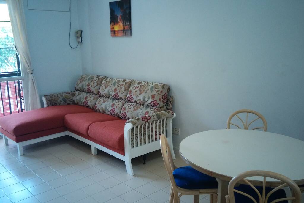 Round breakfast table with matching cane high chairs adjoining living room sofa