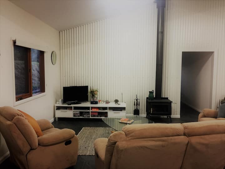 Living room with woodfire, TV, DVDs and games.