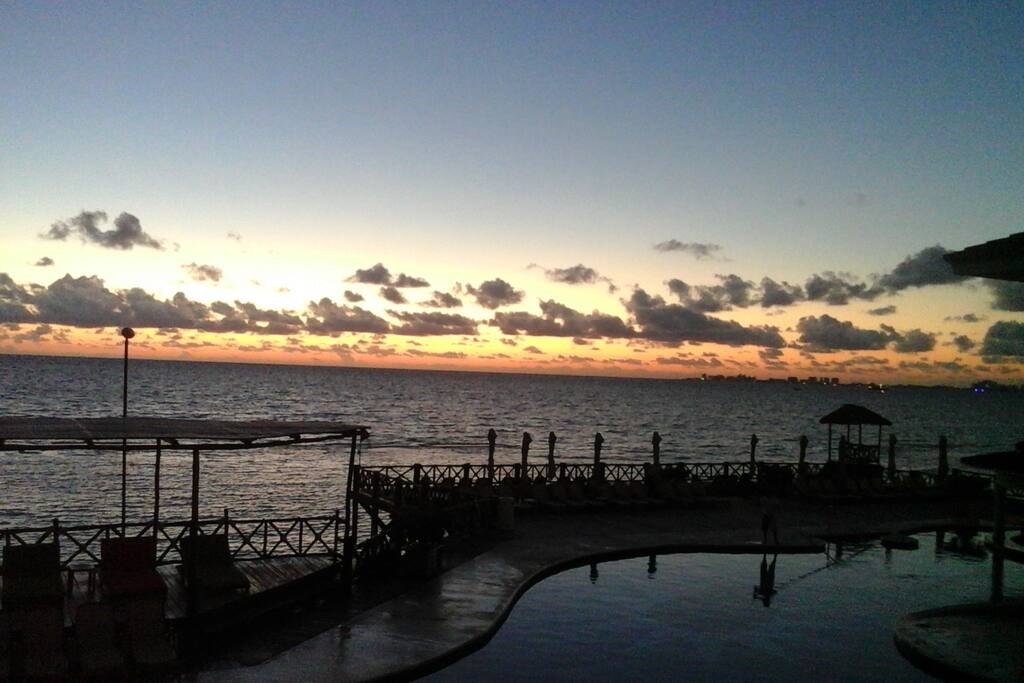 Amanecer con vista de la alberca y la playa.