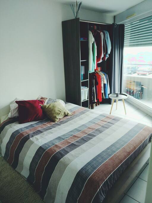 Chambre pour deux personnes, grande baie vitrée avec vue sur la terrasse et l'extérieur. Le dressing vous est laissé à disposition
