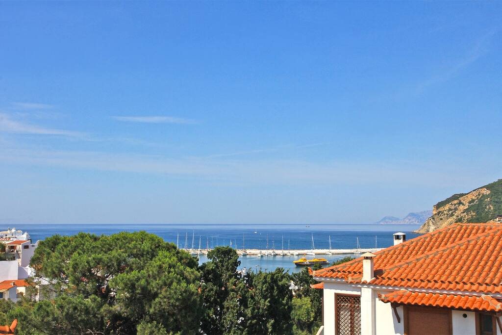 Panoramic view to town, harbour and neigbouring Alonnissos island from private covered balcony.