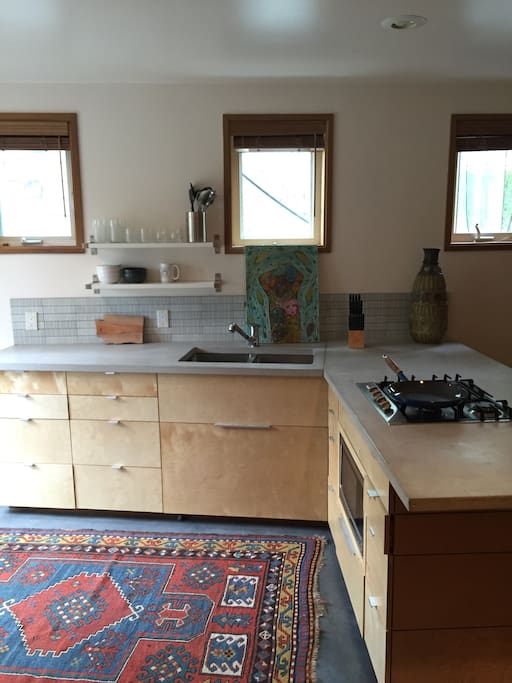 Kitchen includes a gas cooktop, microwave, and full size refrigerator with freezer.