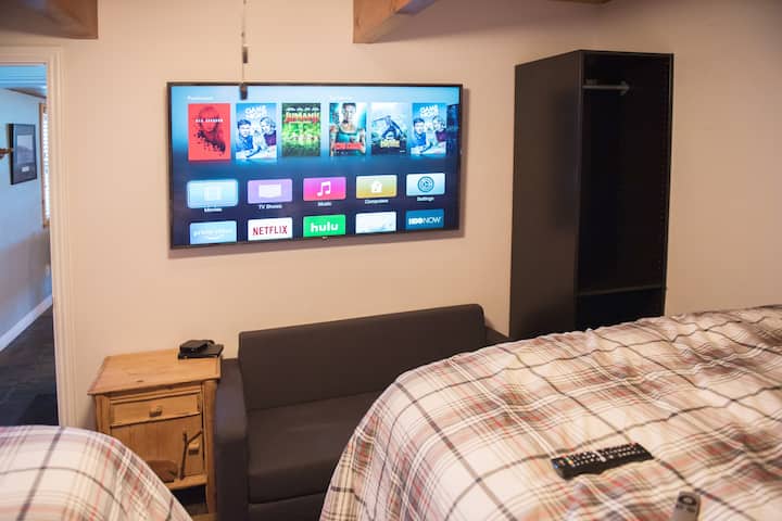 Tout nouvel écran plat 4K 60"dans la chambre d'hôtes avec toutes les chaînes haut de gamme et plus de 180 films Apple TV (Netflix aussi).  Le petit canapé sur la photo se transforme en petit lit jumeau pour les enfants ou...