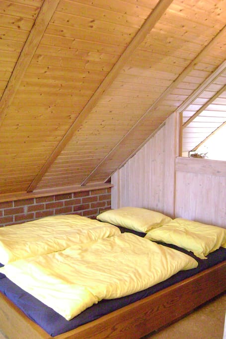 Gemütliches Doppelbett unter der Schräge