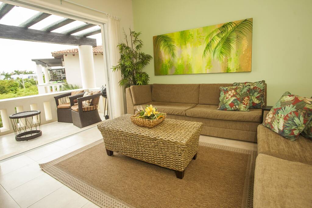 The living room boasts high ceilings and plenty of seating.