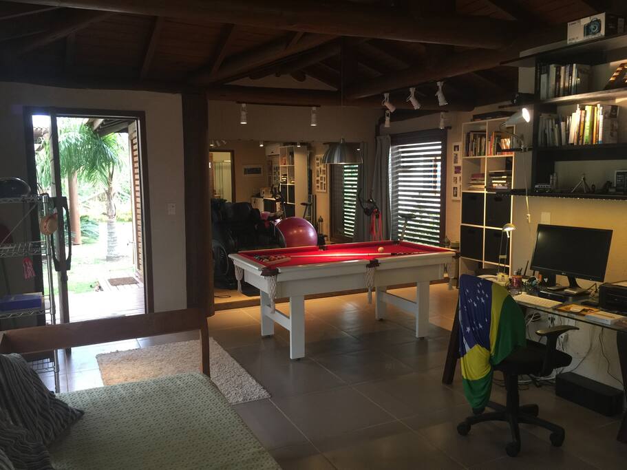 Bangalô home office studio, com espaço fitness e bilhar integrados ao dormitório.