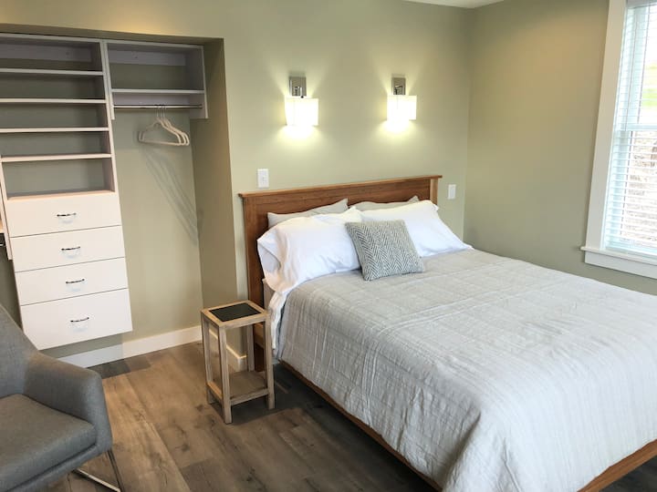 Dormitorio delantero con cama tamaño Queen y armario abierto.