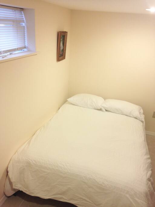 Clean, full-sized bed in renovated bedroom.