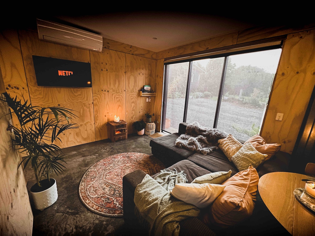 Living area with north facing sliding doors open to front yard and beautiful vegetated garden. Privacy and block out blinds installed or leave blinds open to watch native birdlife visit garden.