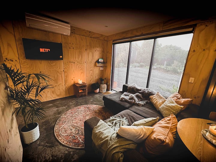 Living area with north facing sliding doors open to front yard and beautiful vegetated garden. Privacy and block out blinds installed or leave blinds open to watch native birdlife visit garden.