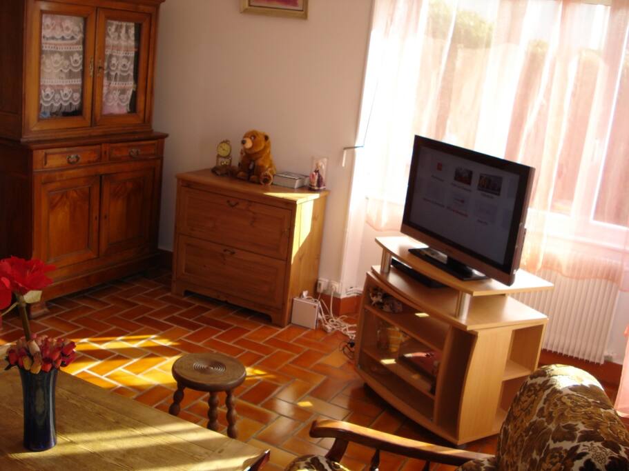 le salon possede un television , un canape et deux fauteuils