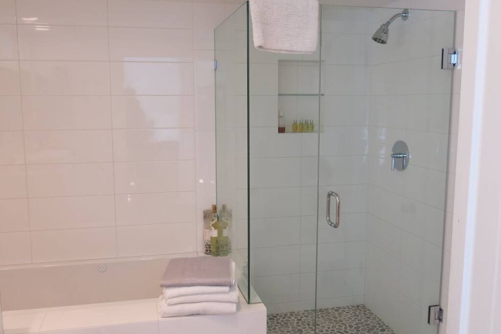 A pebble stone floor enhances the separate shower and jacuzzi tub.
