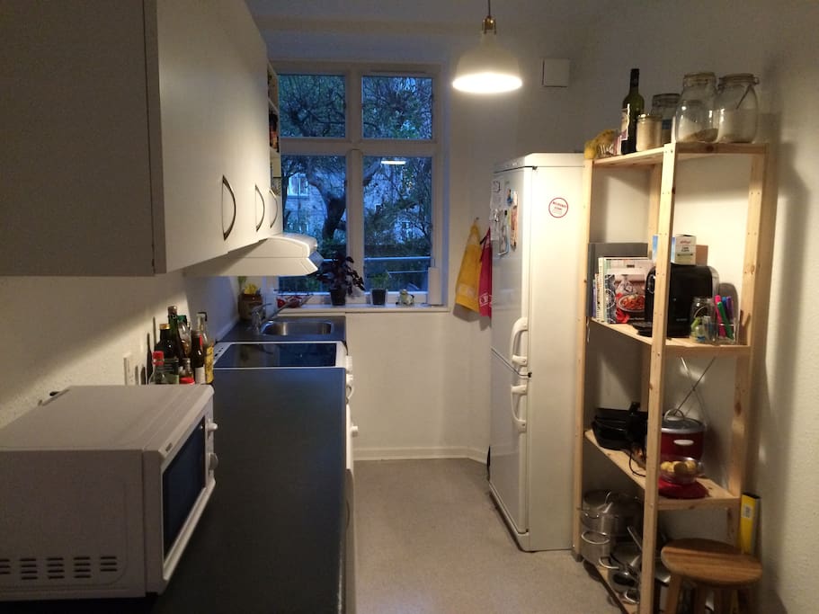 Kitchen with microwave, ovenrefrigerator + freezer.