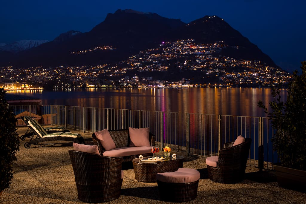 The large terrace at night offers unparalleled views over Lake Lugano and the City