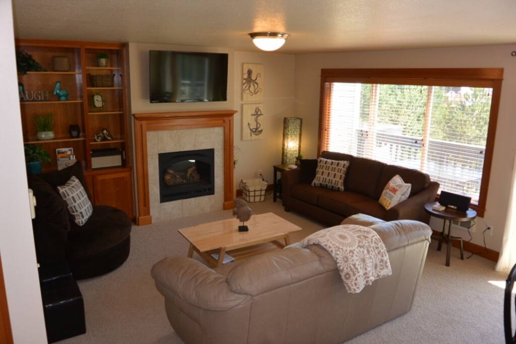 Spacious living room with large windows, gas fireplace, flat screen TV and much more.