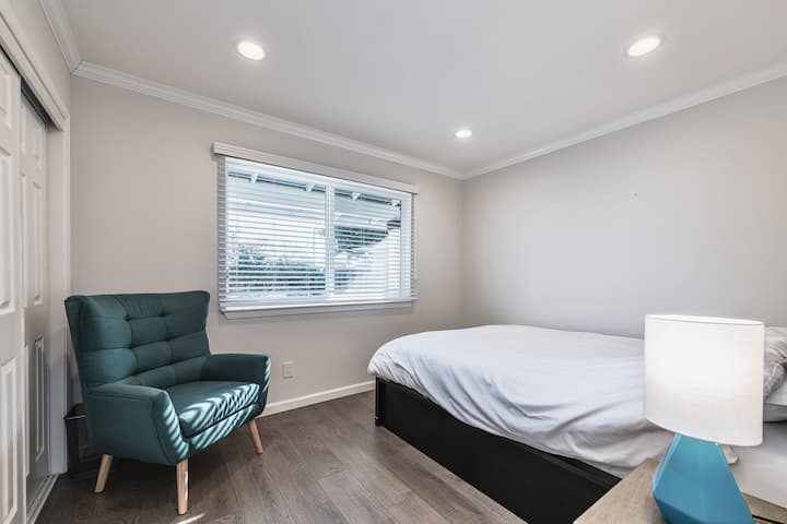 Slaapkamer B: beschikt over een queensize bed met traagschuimmatras, nachtkastje en een lamp met een leesstoel.