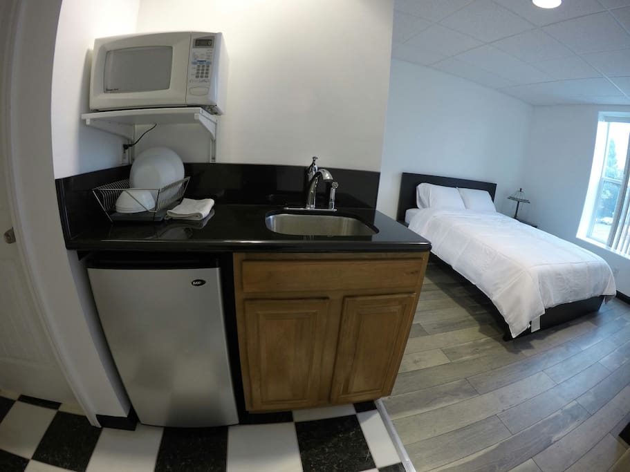 Private mini kitchenette area. Mini fridge, microwave, toaster, plates, cups, utensils, and sink