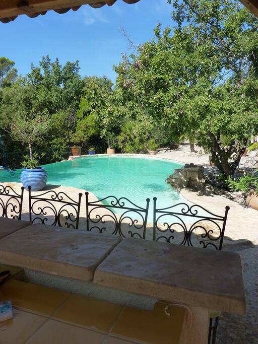 Espace Piscine clôturé avec accès sécurisé : Piscine avec débordement, espace bar et barbecue couvert équipé d’un évier et d’un frigo. Éclairage. Chaises longues.