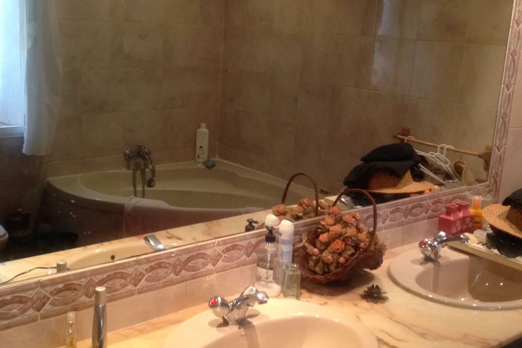 Baño completo con doble lavabo y bañera doble en forma de concha.