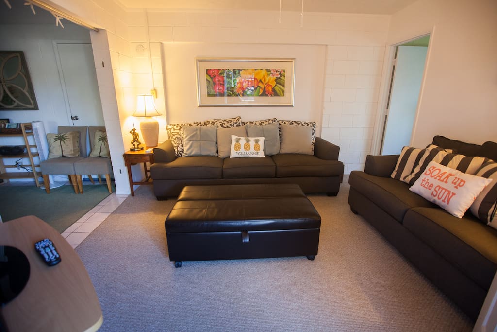 Living room. Couch has a queen sized pull-out bed. Ottoman has a twin pull-out bed that can be set up in the dining room area if both pullout beds are used simultaneously.