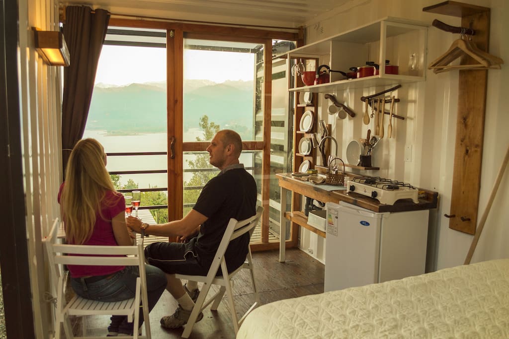 interior del refugio, tendrás todo lo necesario: cocina equipada, baño privado, comedor, una cómoda cama, balcón mirador, terraza y una impresionante vista al lago y a la cordillera.
