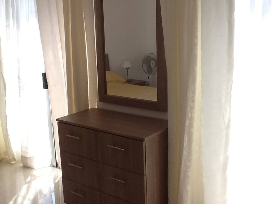 A chest of draws with large mirror, were you can put your make up on.