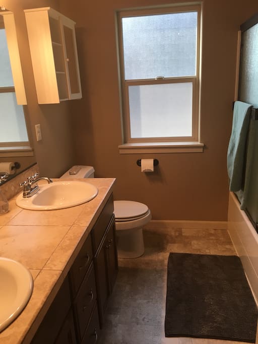 Clean bathroom with dual sinks and detachable shower head