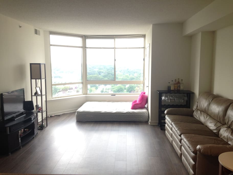 Living room area with couch and queen-size mattress.