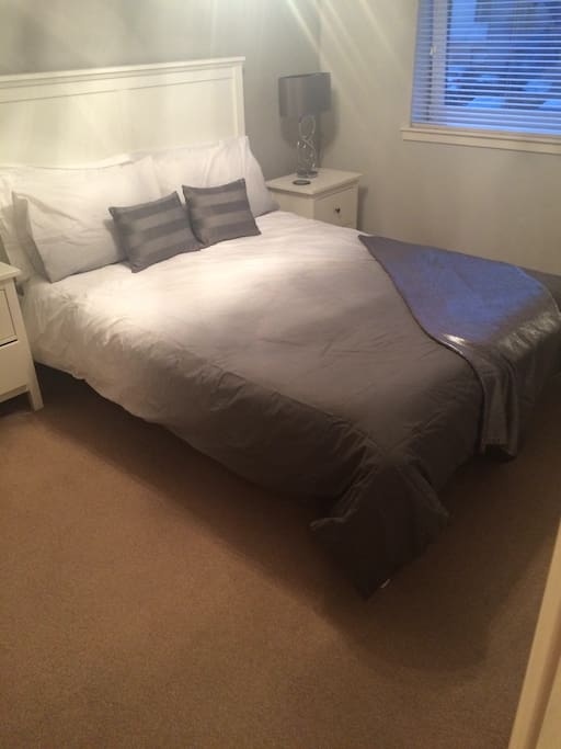 Master bedroom with King sized bed, memory foam mattress, large TV on wall, dressing table