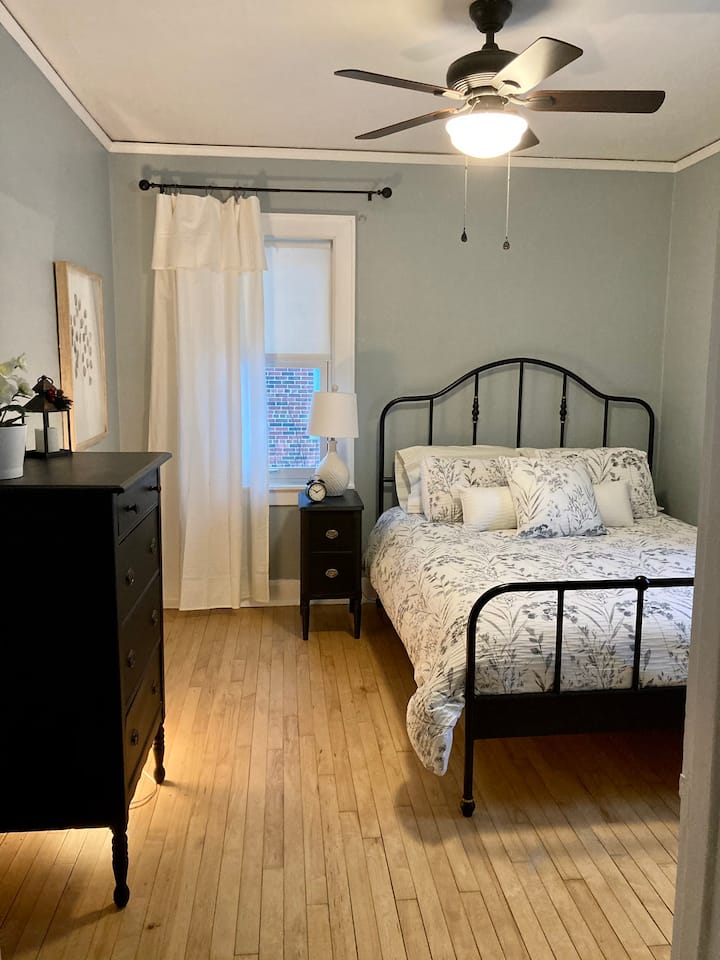 Bedroom  with a queen bed located on the main floor next to bathroom with shower. 