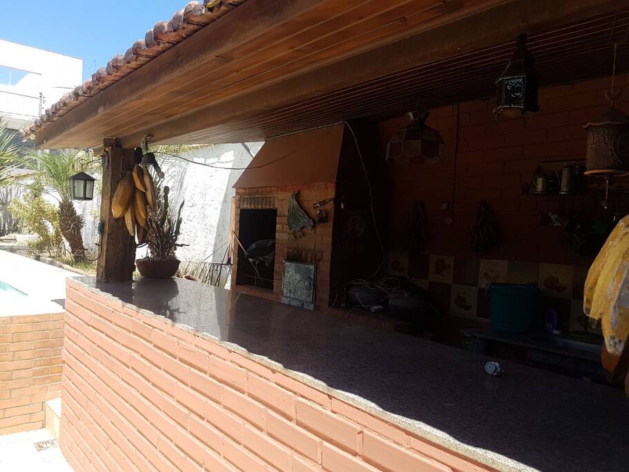 Área gourmet, churrasqueira, fogão a lenha, freezer.
