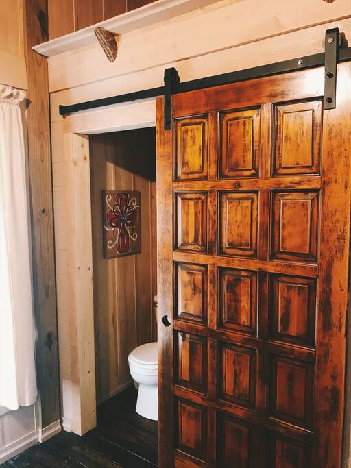Bathroom with standup shower behind sliding barn door.