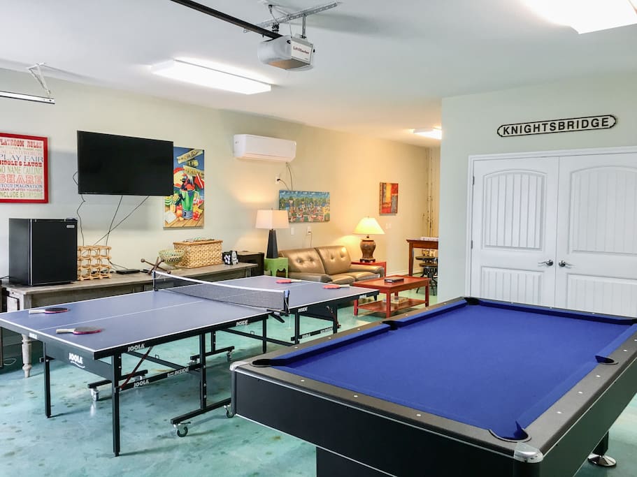The entertainment room includes a pool and ping pong table as well as a flat screen TV and sofa.