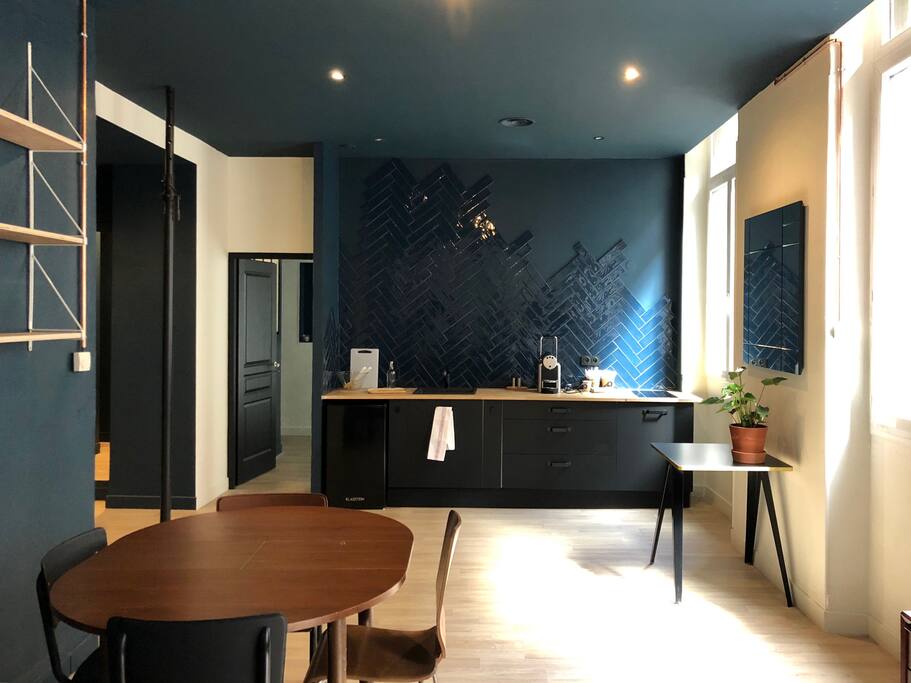L'espace cuisine est ouvert sur le salon. Machine à café, plaques de cuisson, et four micro ondes